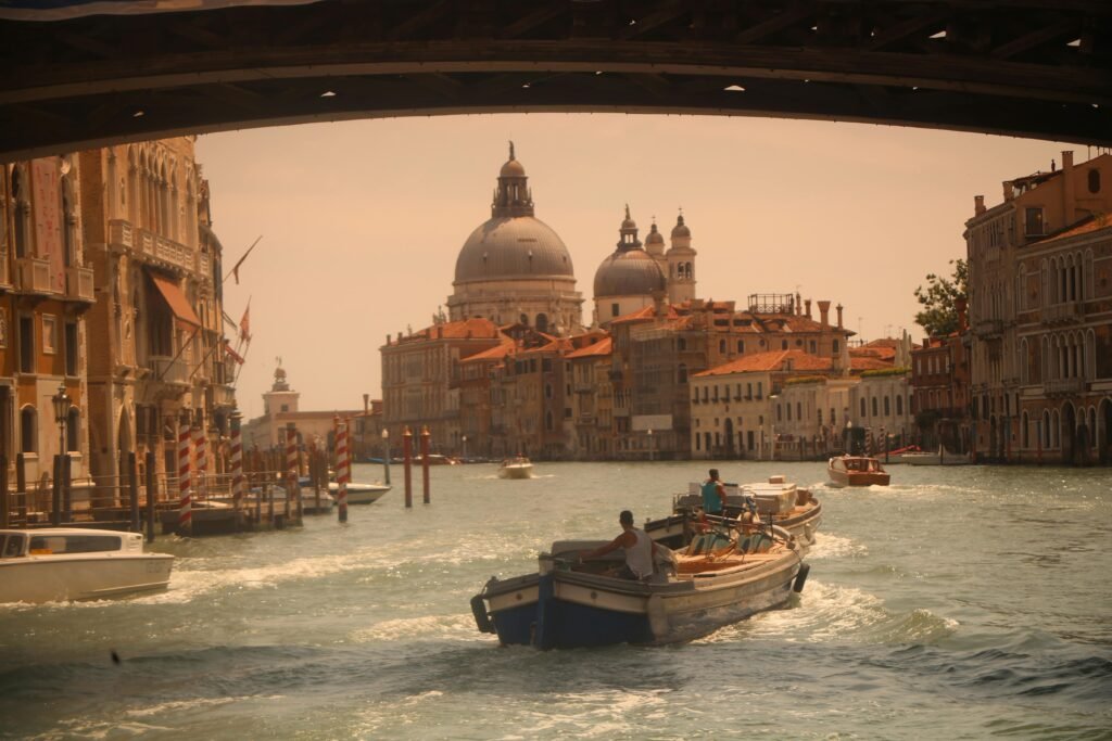 Iconic view of Venice's Grand Canal with boats and Santa Maria della Salute in the backdrop.